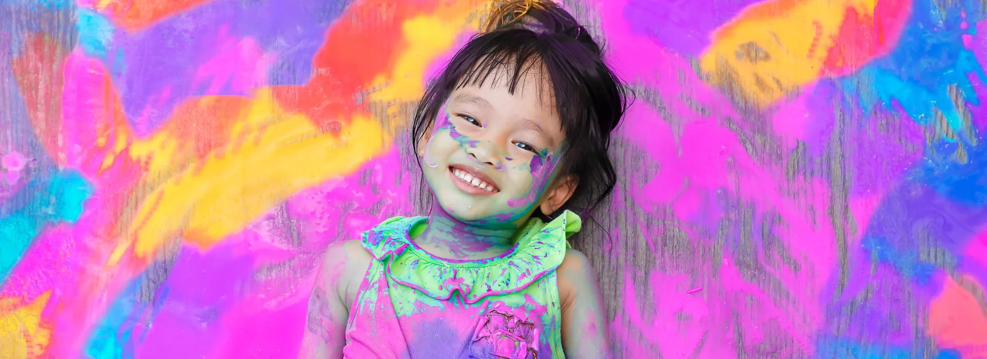 smiling girl covered in paint